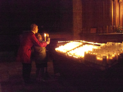 A child being helped to light a candle